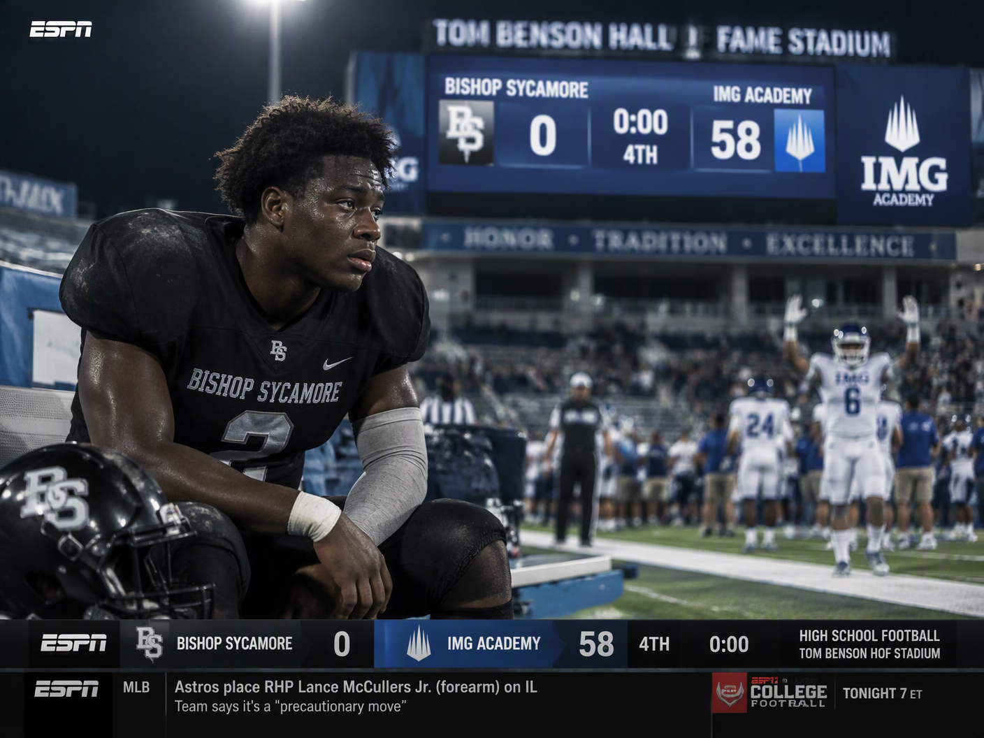 A dejected Bishop Sycamore football player sits alone on the sideline helmet off under stadium lights, with a blurry scoreboard showing 58-0 defeat and an IMG Academy player celebrating in the background during a 2021 ESPN broadcast.