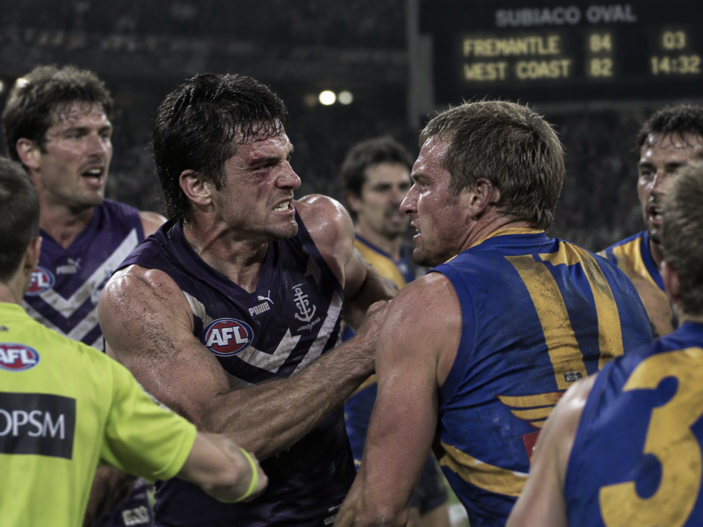 Action shot of Fremantle’s Dale Kickett and West Coast’s Phillip Read locked in a physical fight during the 2000 Western Derby at Subiaco Oval, with intense facial expressions and blurred figures in the heated melee under the stadium lights.